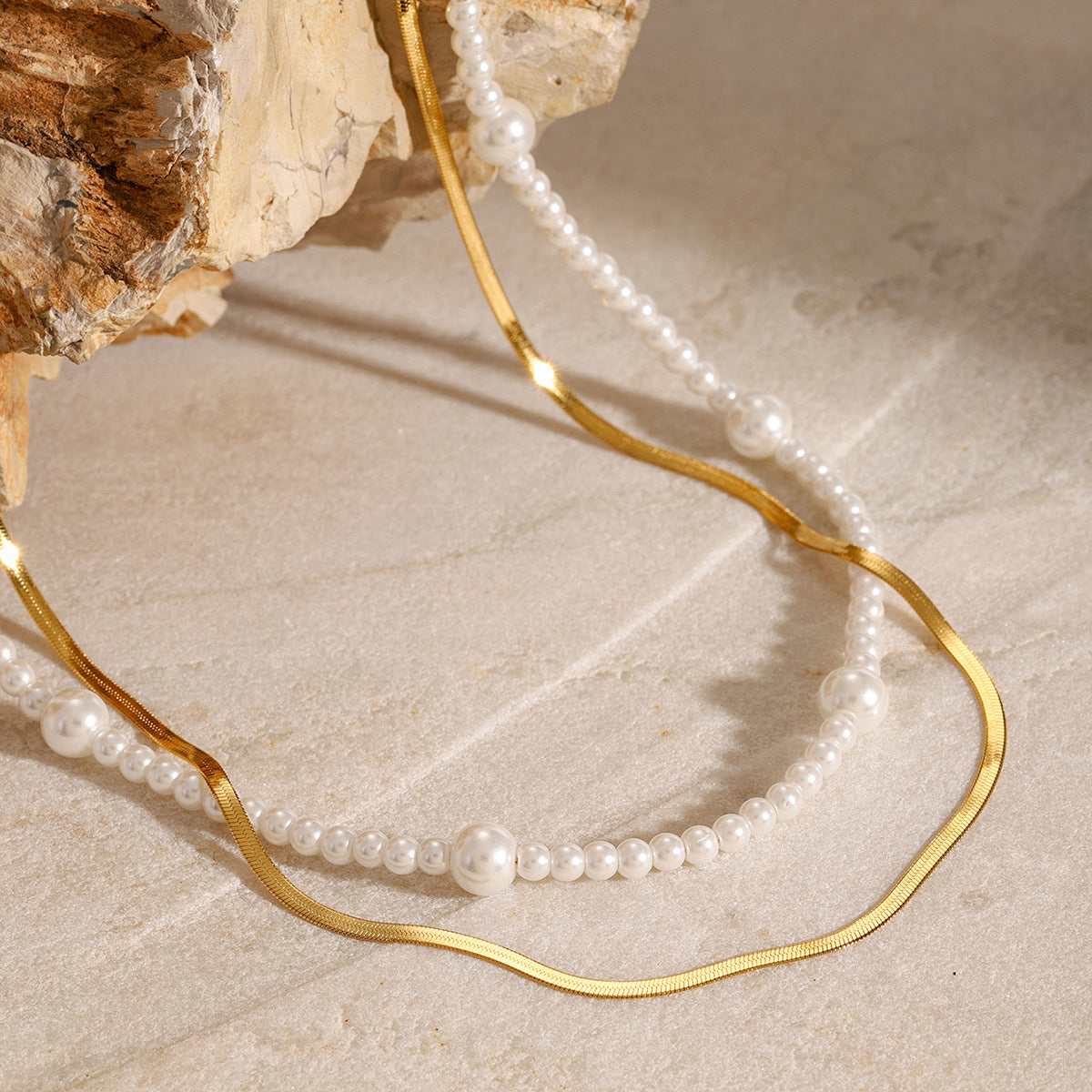 Close-up of pearl-look bead stations beside the flat chain