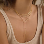 Long gold tone Y-drop necklace worn on model