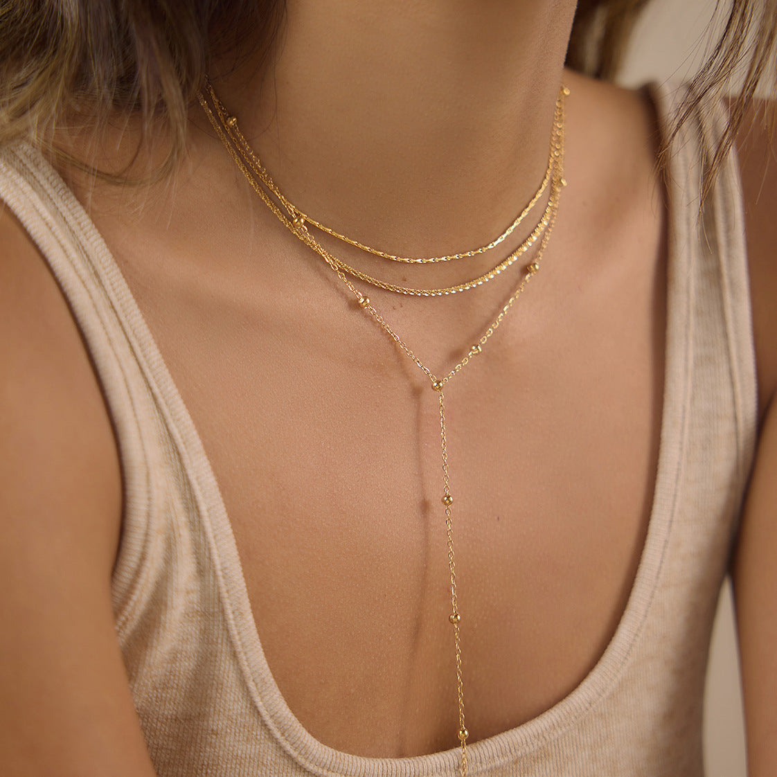 Long gold tone Y-drop necklace worn on model