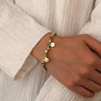 model wearing the gold and turquoise-color shell bead bracelet