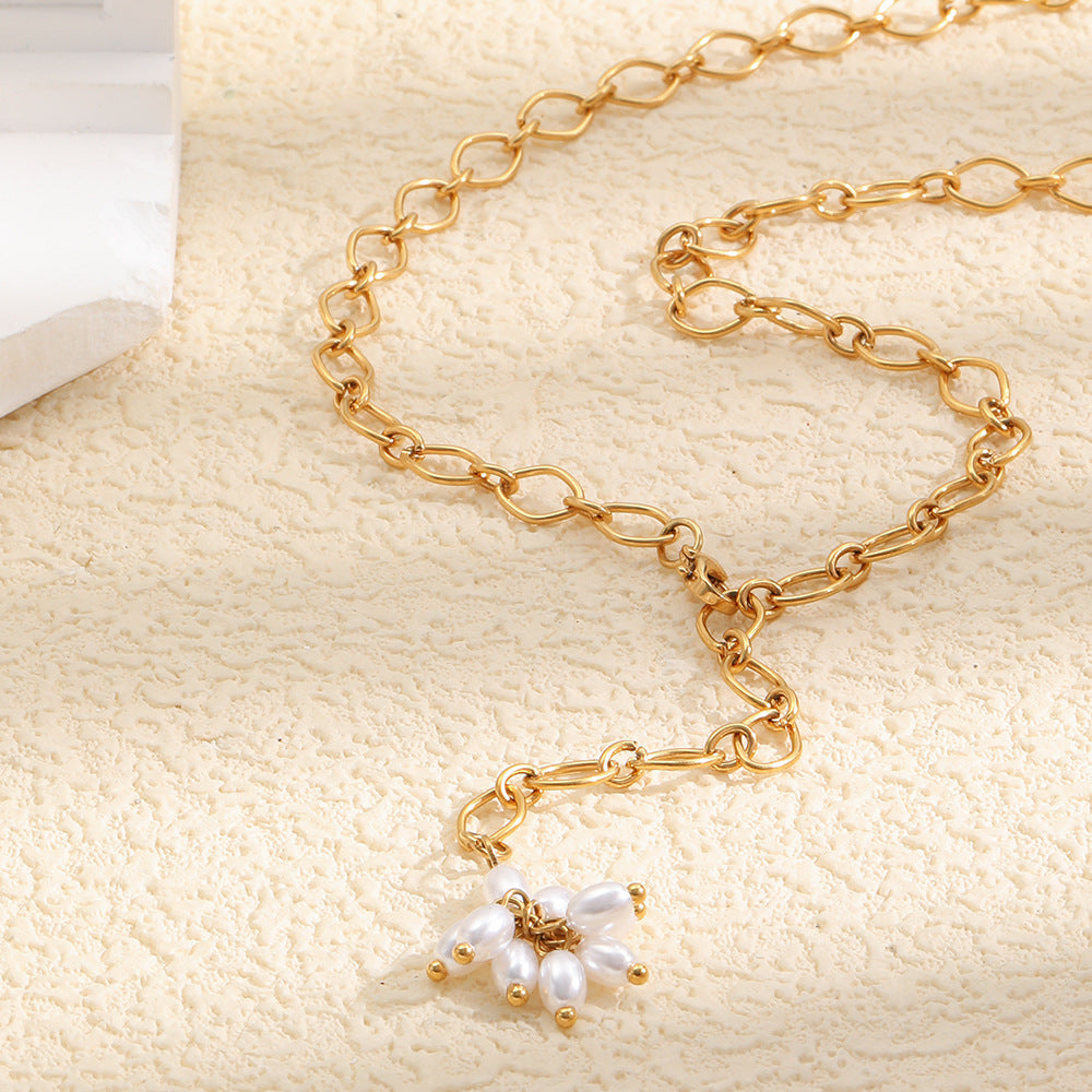 Gold plated stainless steel flower Y necklace arranged on a stone surface