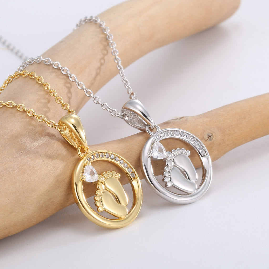 close view of clear accents around gold and silver footprint pendants