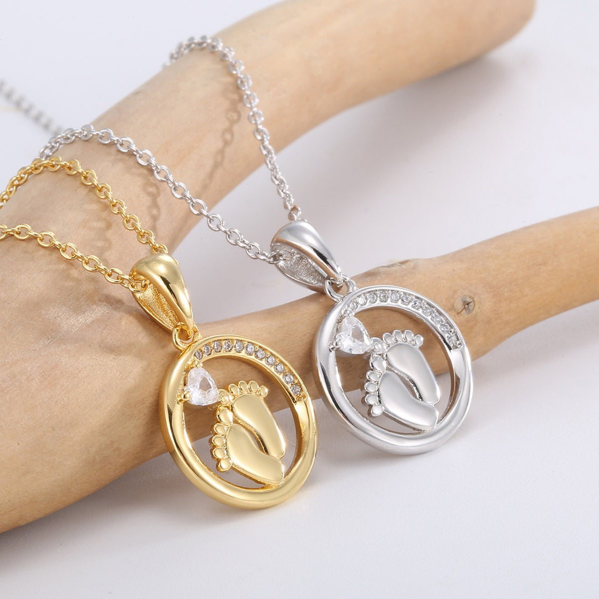 close view of clear accents around gold and silver footprint pendants