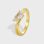gold plated brass bypass ring with pear-cut clear center stone