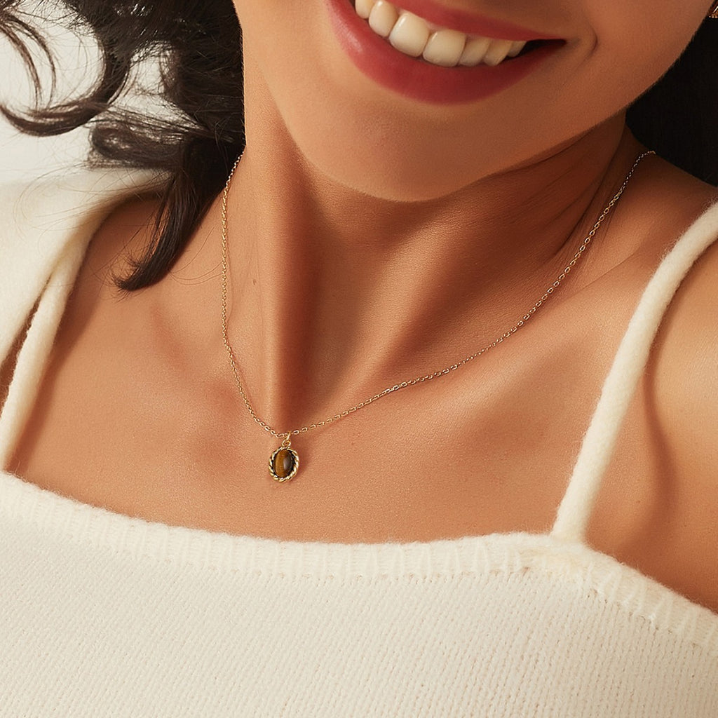 model wearing a small oval tiger's eye necklace at the collarbone