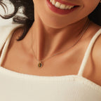 model wearing a small oval tiger's eye necklace at the collarbone
