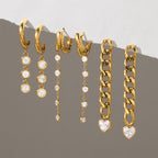 Round drop and heart-ended chain earrings hanging from a ledge
