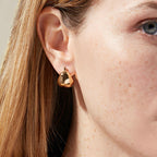 gold plated 316L stainless steel chunky dome huggie worn on the ear