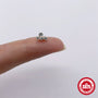 Silver-tone three-stone stud on a fingertip