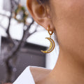 gold plated clear stone crescent moon earring worn in profile