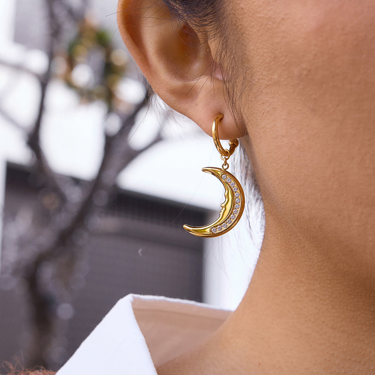 gold plated clear stone crescent moon earring worn in profile