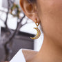 gold plated clear stone crescent moon earring worn in profile