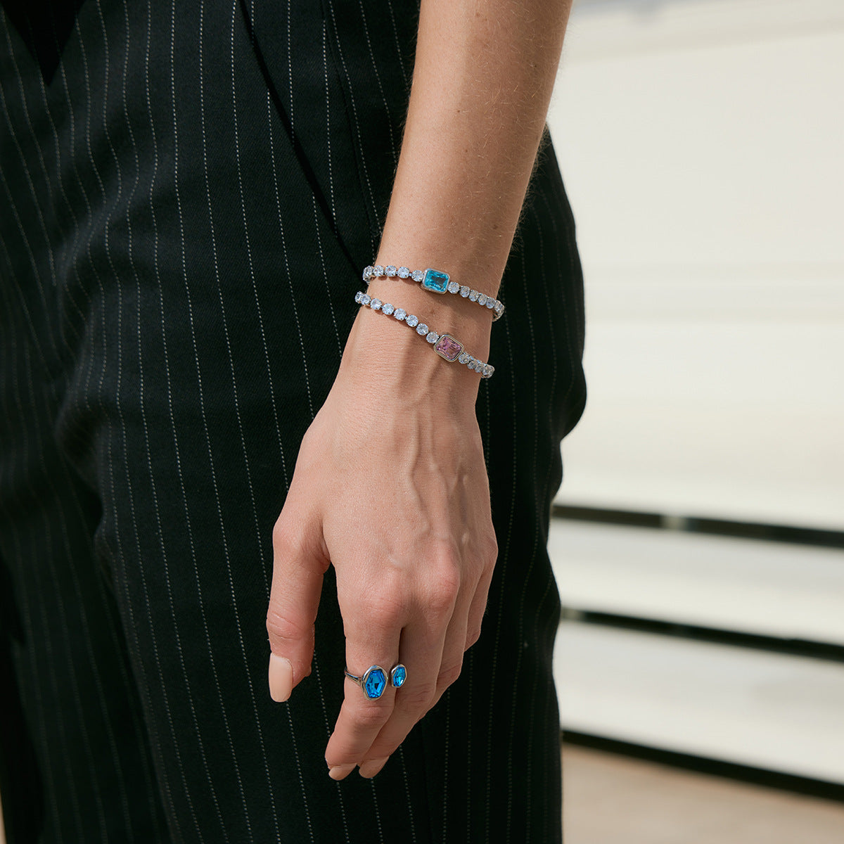 Blue two-stone ring worn with bracelets
