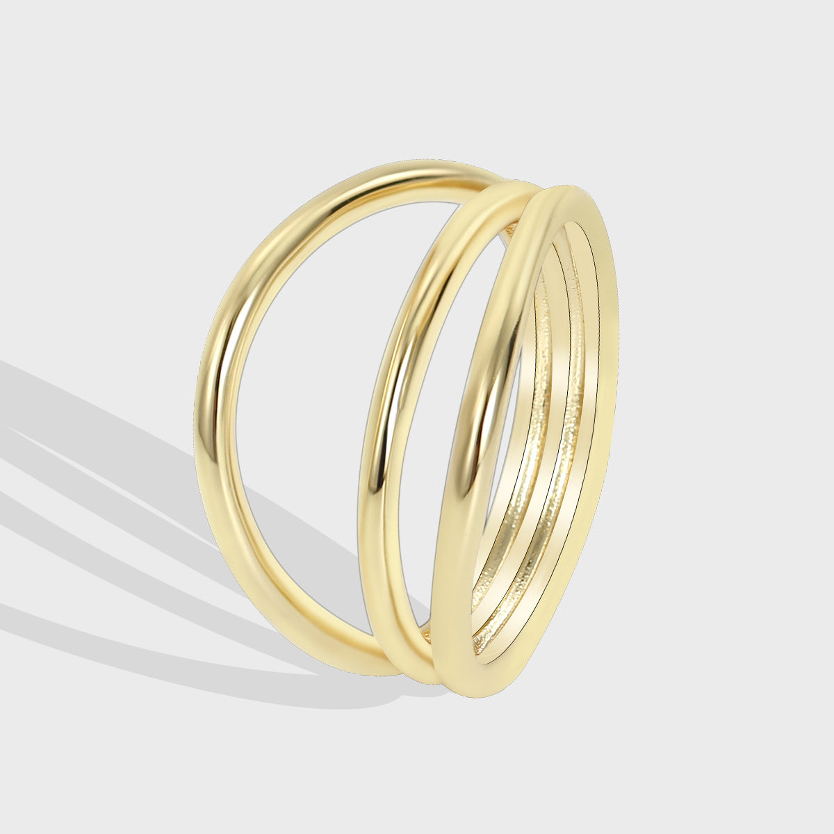 isolated gold plated brass ring with three crossing bands