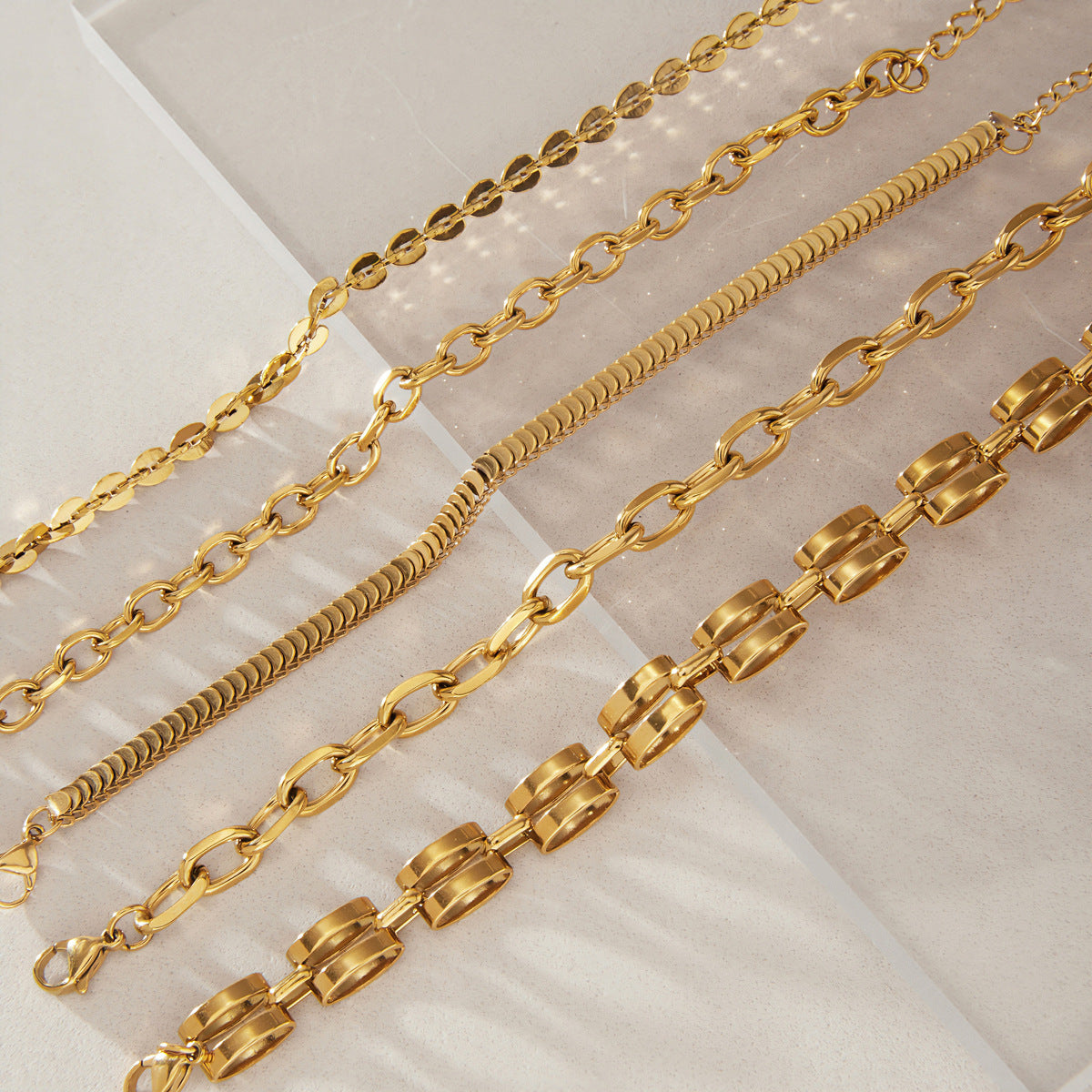 Five gold tone chain bracelet profiles in parallel rows