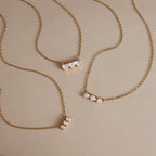 Three gold tone necklaces with different clear stone shapes