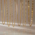 Six gold tone chain necklace profiles hanging side by side