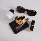 gold plated spiral sun cuff bracelet beside accessories