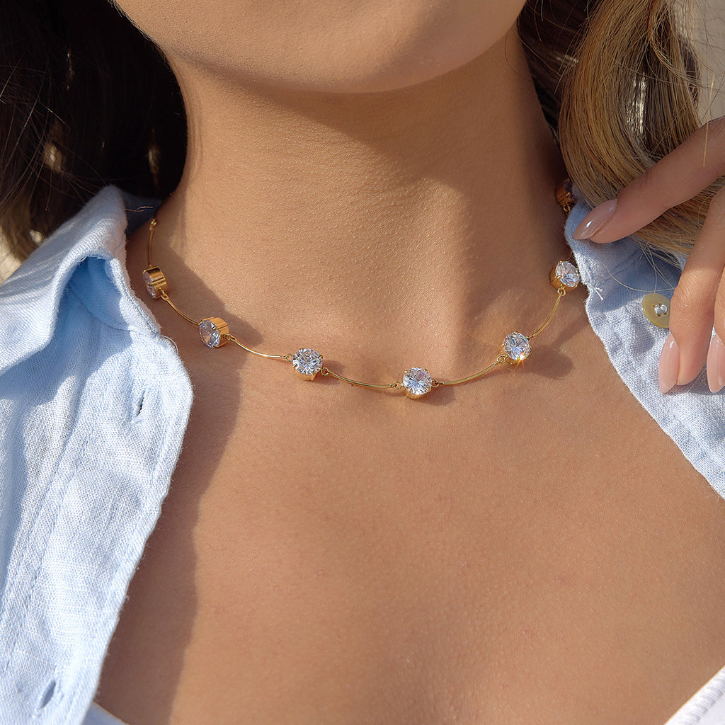 Gold finish curved bar and stone necklace at neckline