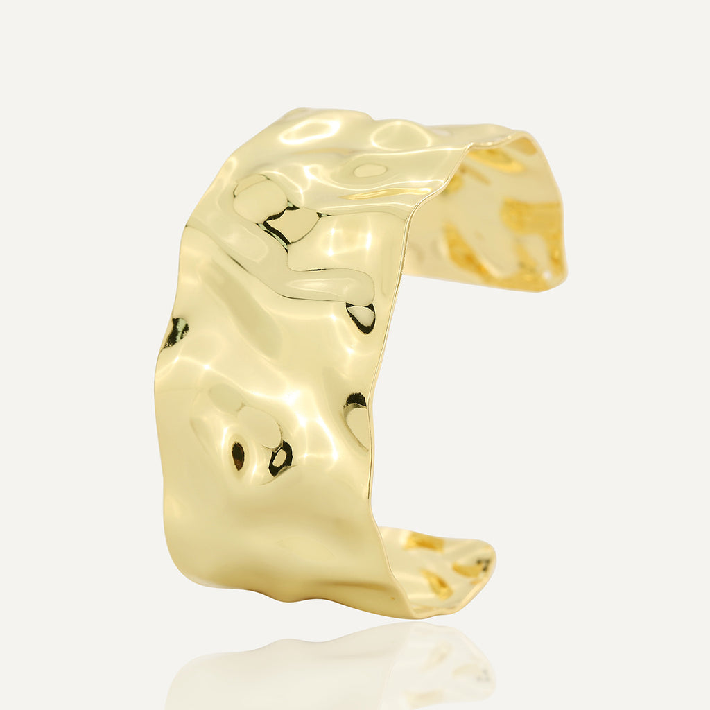isolated gold plated brass wide cuff with hammered ripples