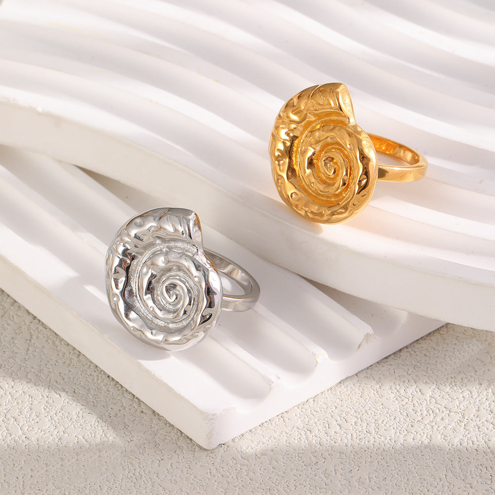 Gold and silver tone spiral shell rings displayed together