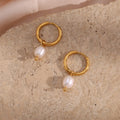 gold plated freshwater pearl drop hoop earrings on a stone surface