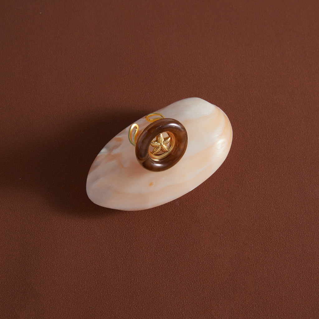 Starfish ring displayed on a shell-shaped surface
