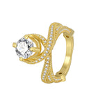 isolated gold plated cross-over clear stone ring on white