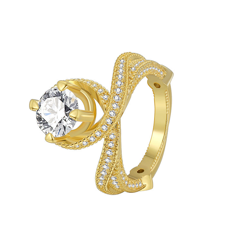 isolated gold plated cross-over clear stone ring on white