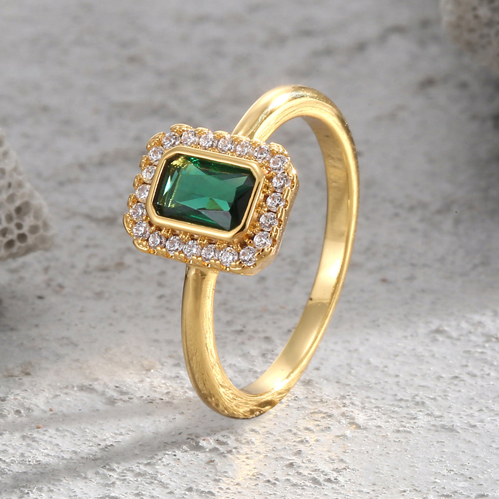 angled green zirconia halo ring on a pale stone surface