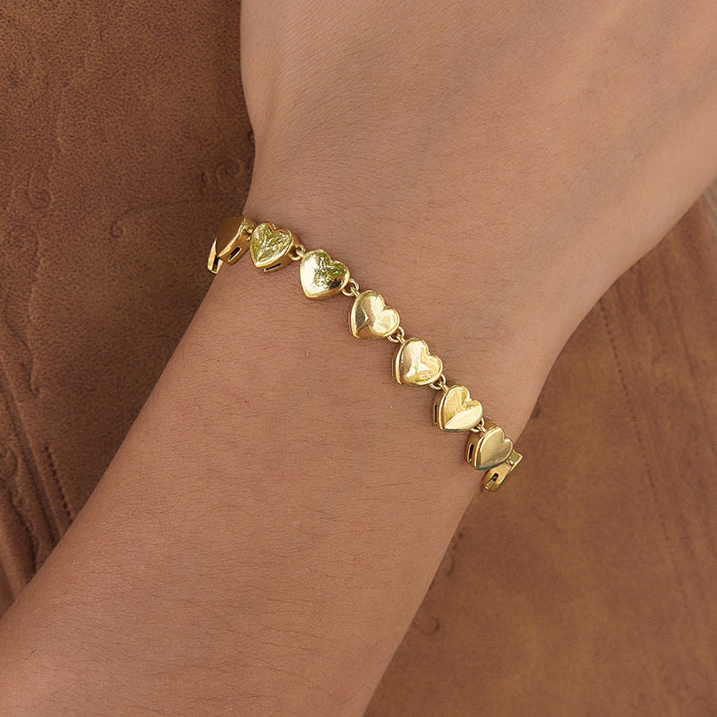 Gold plated stainless steel heart-link bracelet worn on the wrist