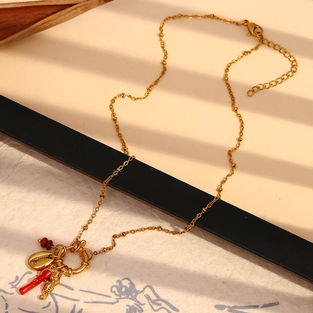 Gold plated marine charm necklace laid across display blocks