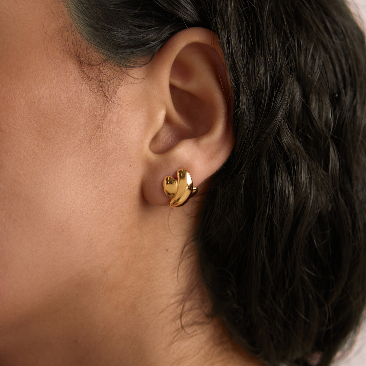 Gold-tone sculptural stud shown on an ear