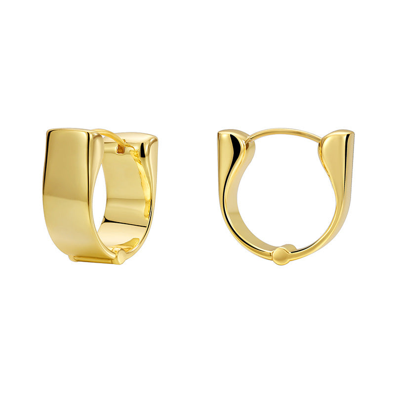 gold plated wide huggie earrings on a white background