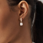White-accent hoop and clear pendant worn on an ear