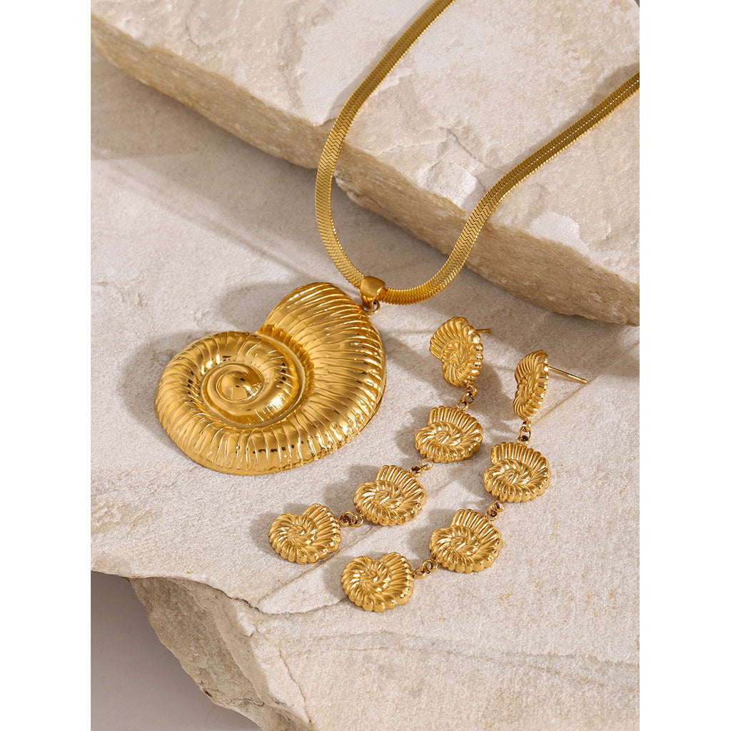 Spiral shell pendant necklace on stone with separate earring references