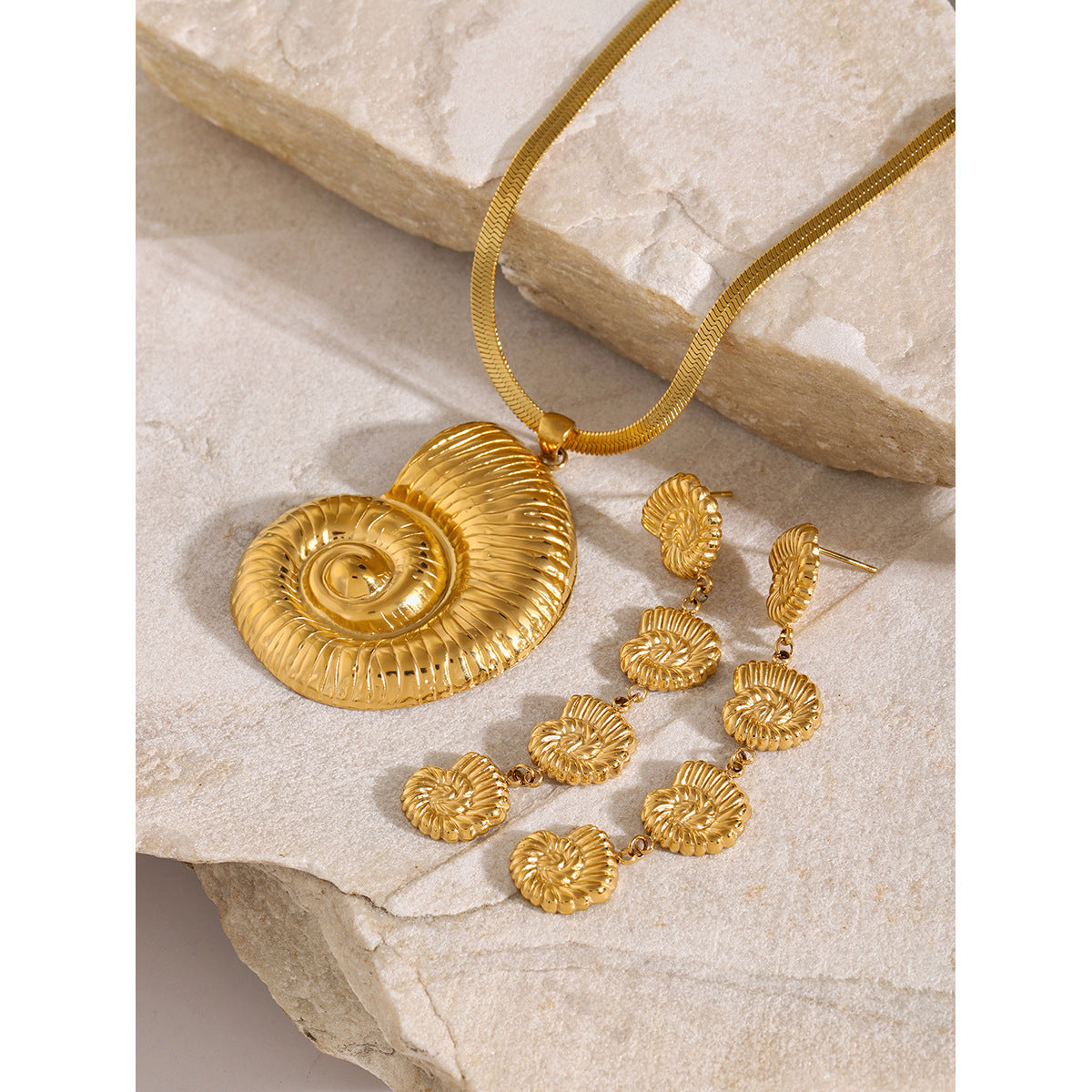 Spiral shell pendant necklace on stone with separate earring references