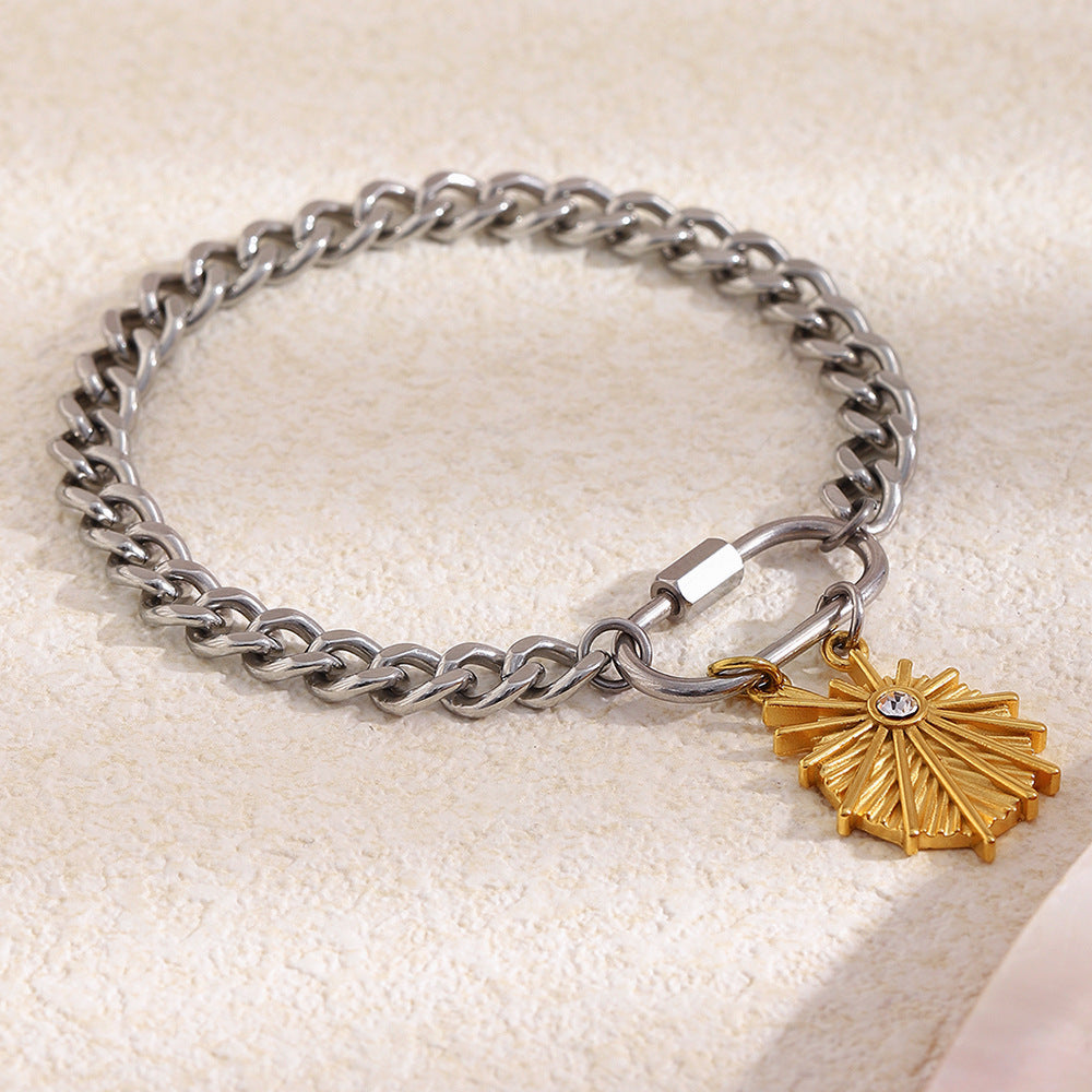 Two-tone curb bracelet with sunburst charm