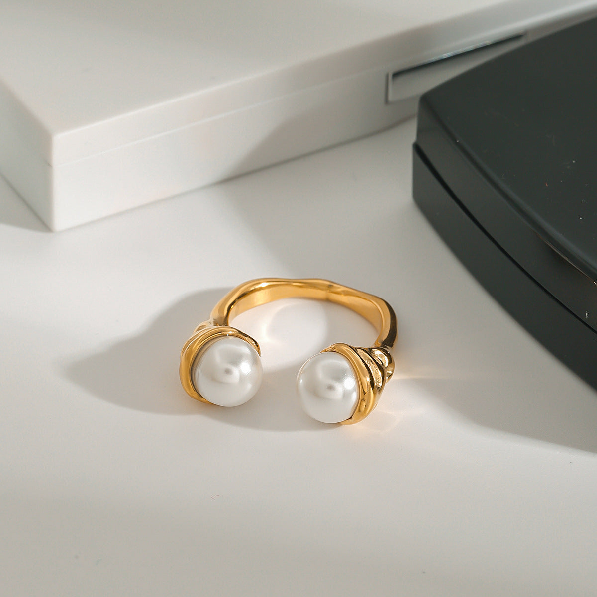 Front view of pearl-look bypass ring on a white surface