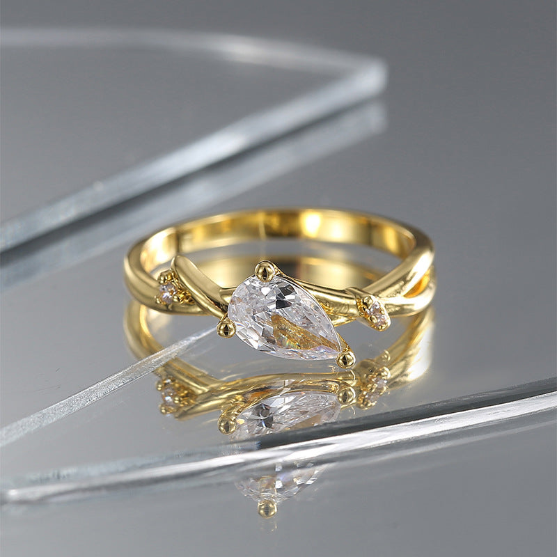 gold plated bypass ring with pear-shaped center and two accents