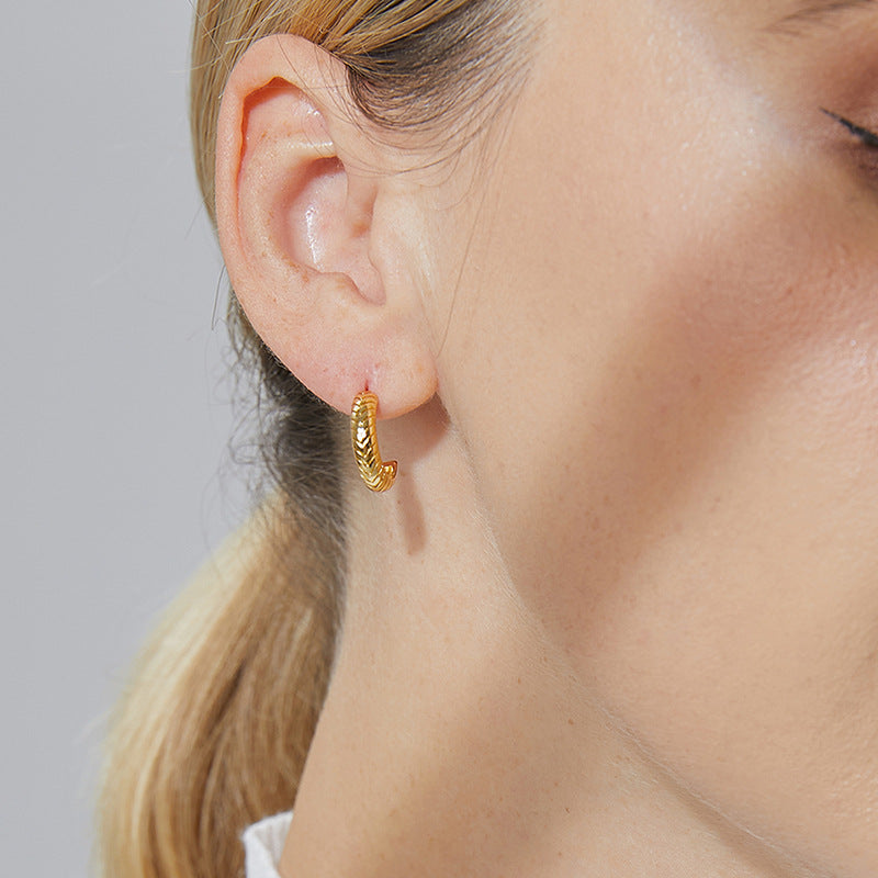 close-up of wheat-texture gold C-hoop earrings