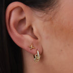 Multi-ring huggie worn beside a small star stud
