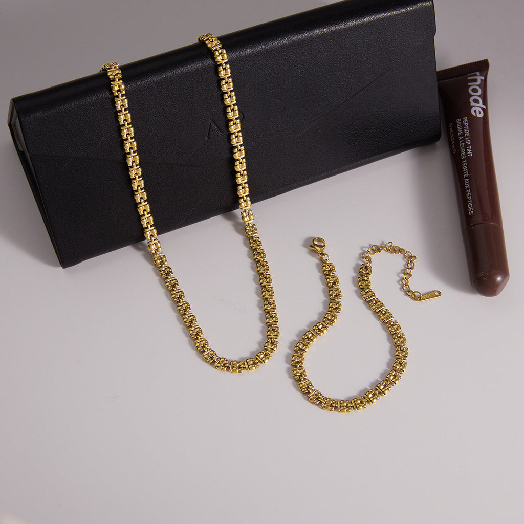 Gold-tone textured necklace and bracelet on a display box