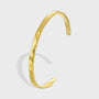 gold plated brass open bangle with a softly faceted surface