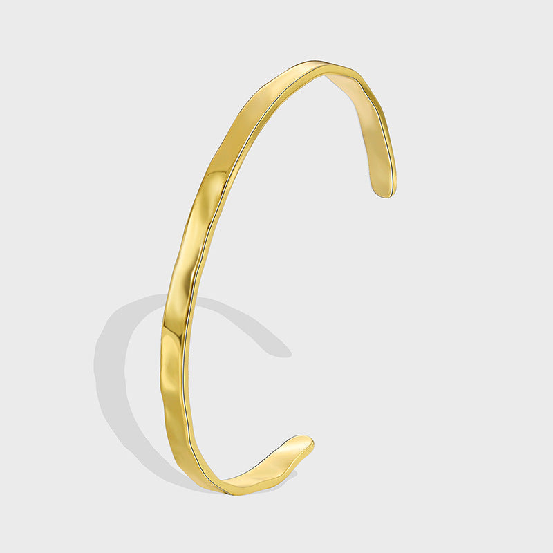 gold plated brass open bangle with a softly faceted surface