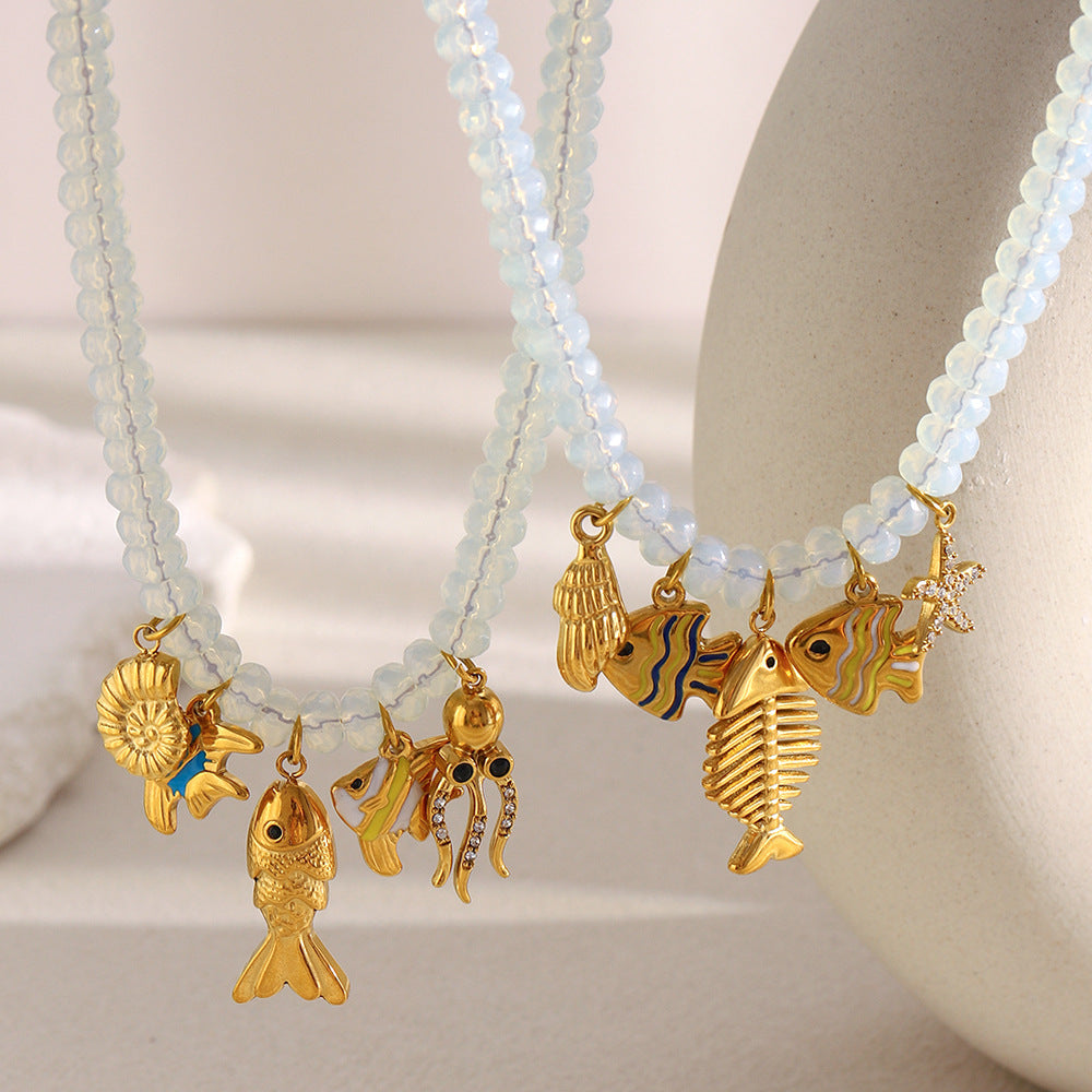 Pale beaded necklace with fish and octopus charms on a light display