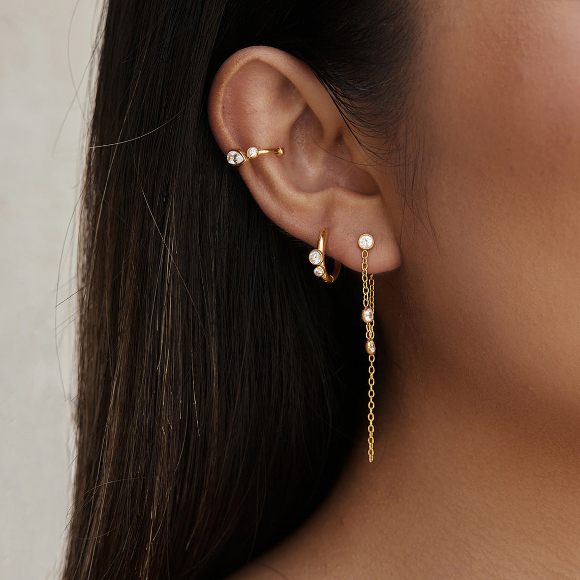 Three-piece ear set worn with long chain stud hoop and cuff