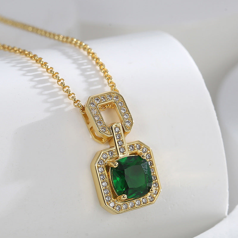 Close-up of the clear-stone upper link and green pendant on white fabric
