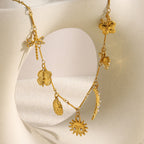 gold plated celestial garden charm necklace with moon sun flowers and insects