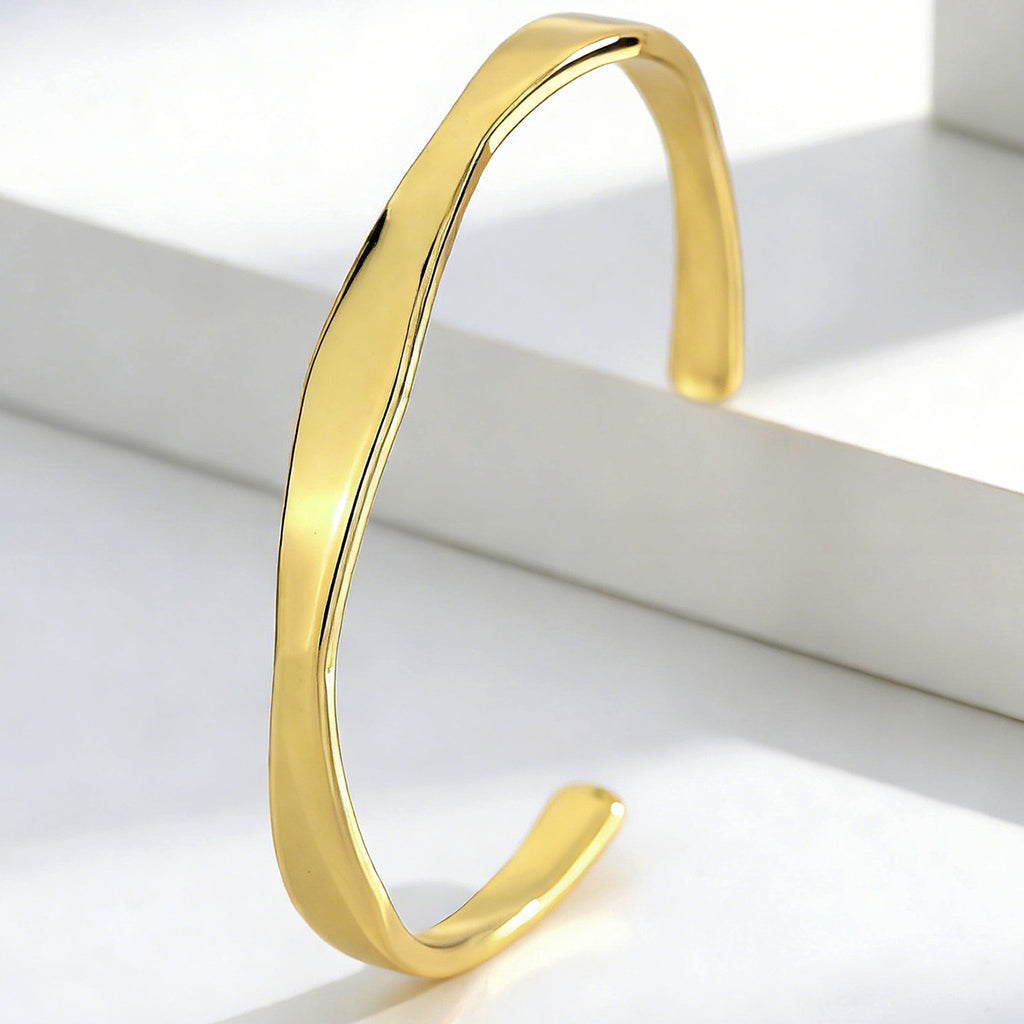 upright view of slim gold plated open cuff with central twist